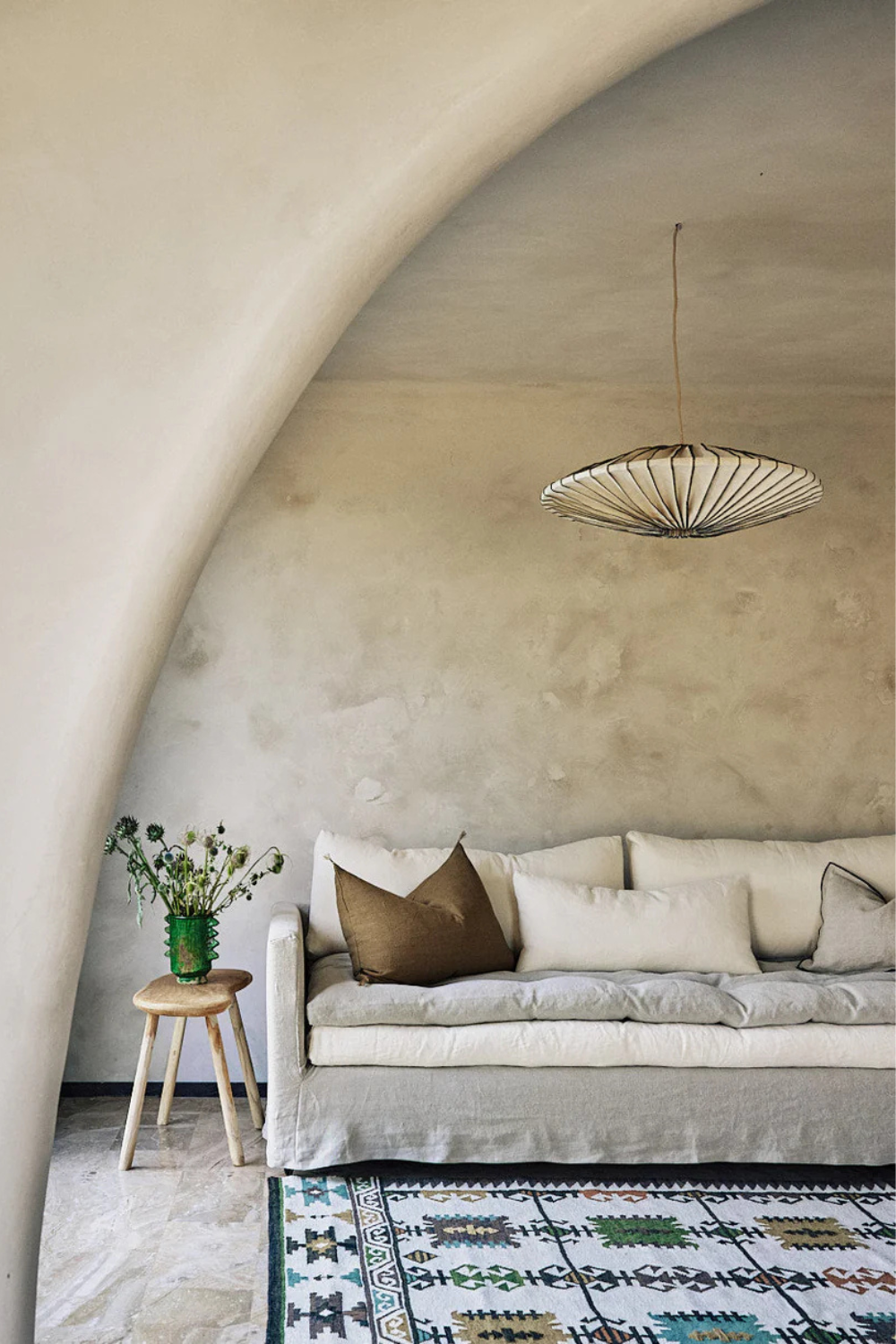 plafonnier-baco-maison-couture-caravane-paris Suspension design en forme d’éventail dans un salon minimaliste avec canapé en lin et tapis coloré