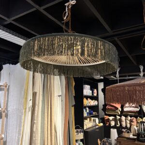 Apportez une touche bohème chic et élégante à votre intérieur avec cette suspension parasol à franges vertes sur structure blanche, un luminaire unique inspiré des parasols vintage des plages méditerranéennes des années 60 : une pièce à la fois déco, originale et lumineuse. Ce luminaire se distingue par son abat-jour en raphia tressé de haute qualité, prolongé par de franges vertes délicates, qui diffusent une lumière douce et chaleureuse dans le salon, la salle à manger ou toute pièce de vie. La structure blanche élégante met en valeur les teintes naturelles du raphia et s’accorde parfaitement avec tous les styles d’intérieur — du plus contemporain au plus bohème. Grâce à sa grande taille M (diamètre 70 cm), cette suspension lumineuse décorative devient un véritable point focal dans votre décoration, apportant à la fois caractère et lumière à votre espace. Compatible avec une ampoule E27, elle est idéale pour créer une ambiance cosy et personnalisée. Choisie par ceux qui recherchent une décoration naturelle et raffinée, cette suspension parasol en raphia vert et blanc est le luminaire parfait pour sublimer un intérieur avec style.